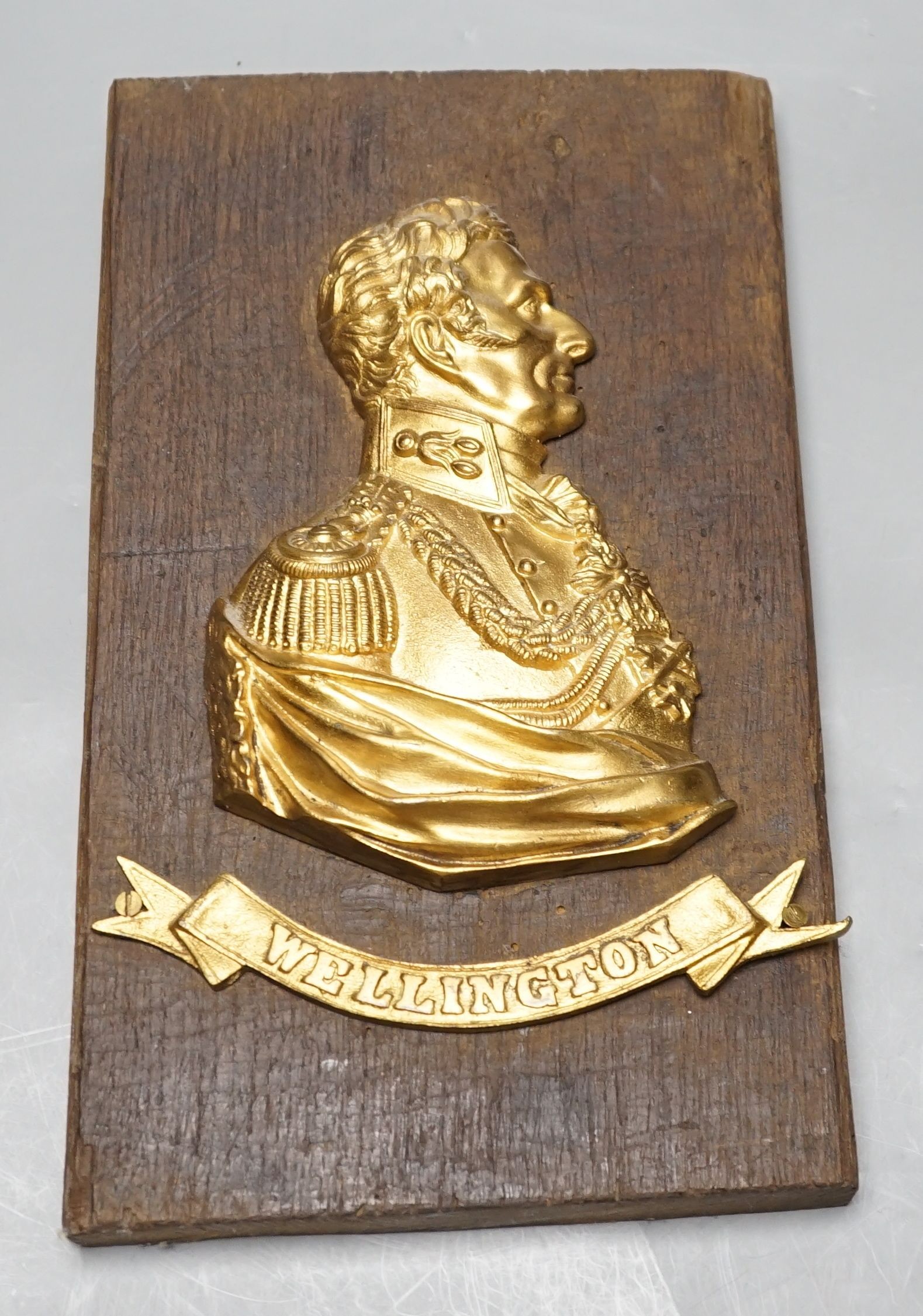 A gilt metal ‘Wellington’ plaque on wooden panel, 30 x 19cm